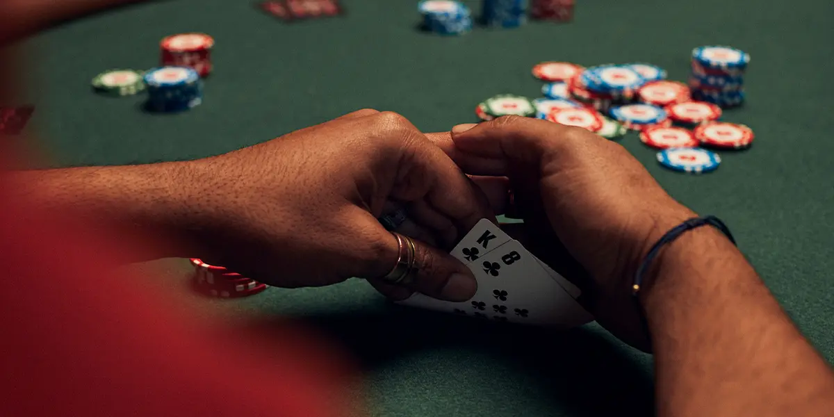 Giocatore di poker con K-8 dello stesso seme, posizione di rischio iniziale