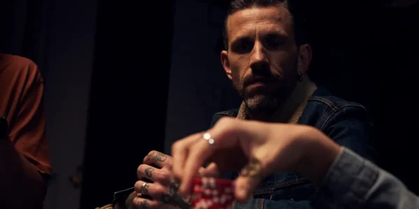 Giocatore di poker osserva l’azione durante una mano cruciale.