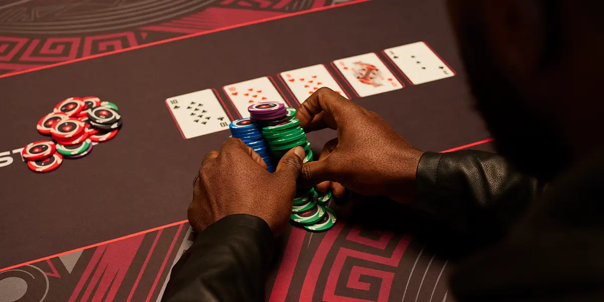 Giocatore di poker che porta verso di sé un grande piatto vinto in un torneo grazie a un bluff con Triple Barrel.