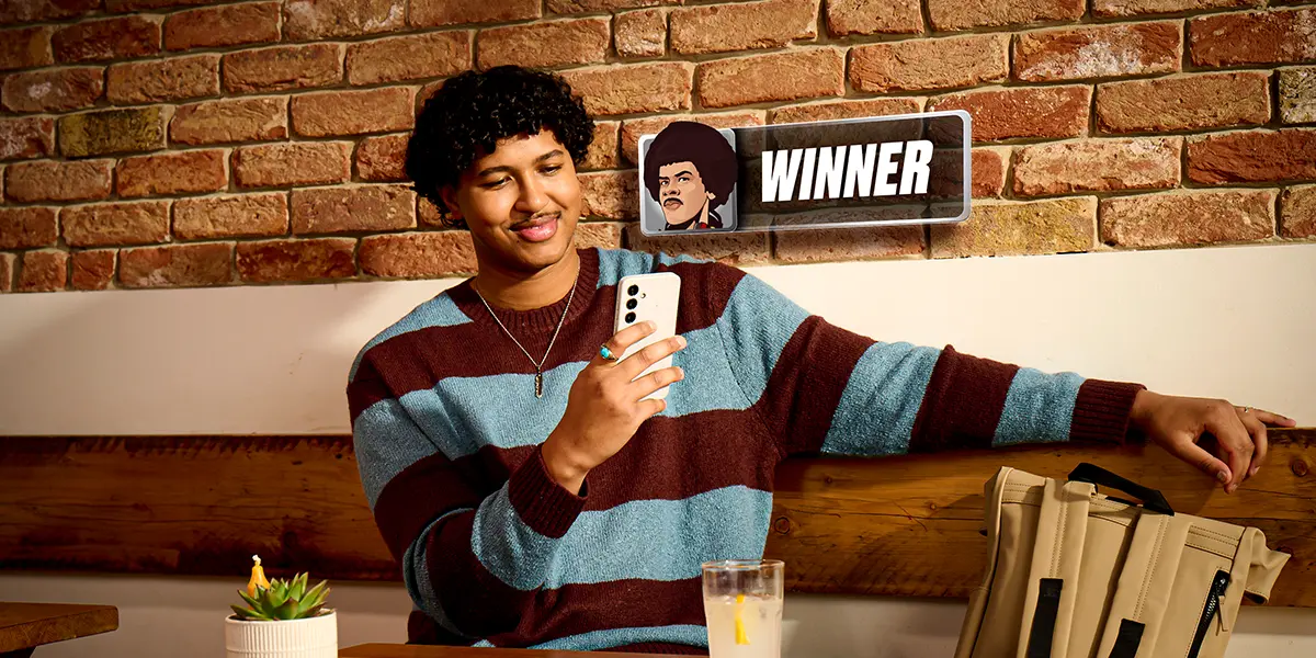 Giocatore di poker sorridente dopo aver vinto un torneo di poker online su PokerStars con il proprio smartphone.